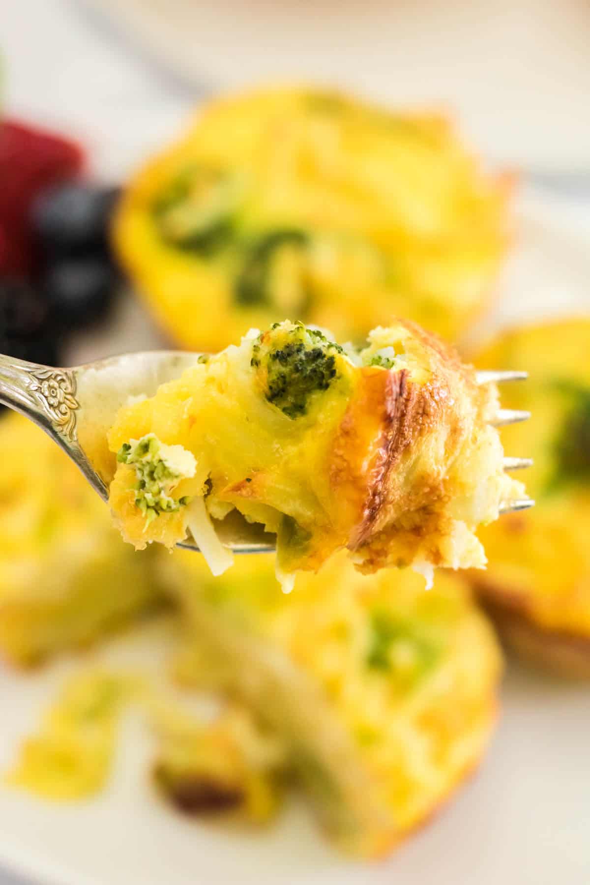 fork holding a bite of eggs with broccoli