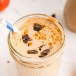 A Chocolate Pumpkin Smoothie in a jelly jar with a sprinkle of pumpkin pie spice and small pieces of chocolate on top