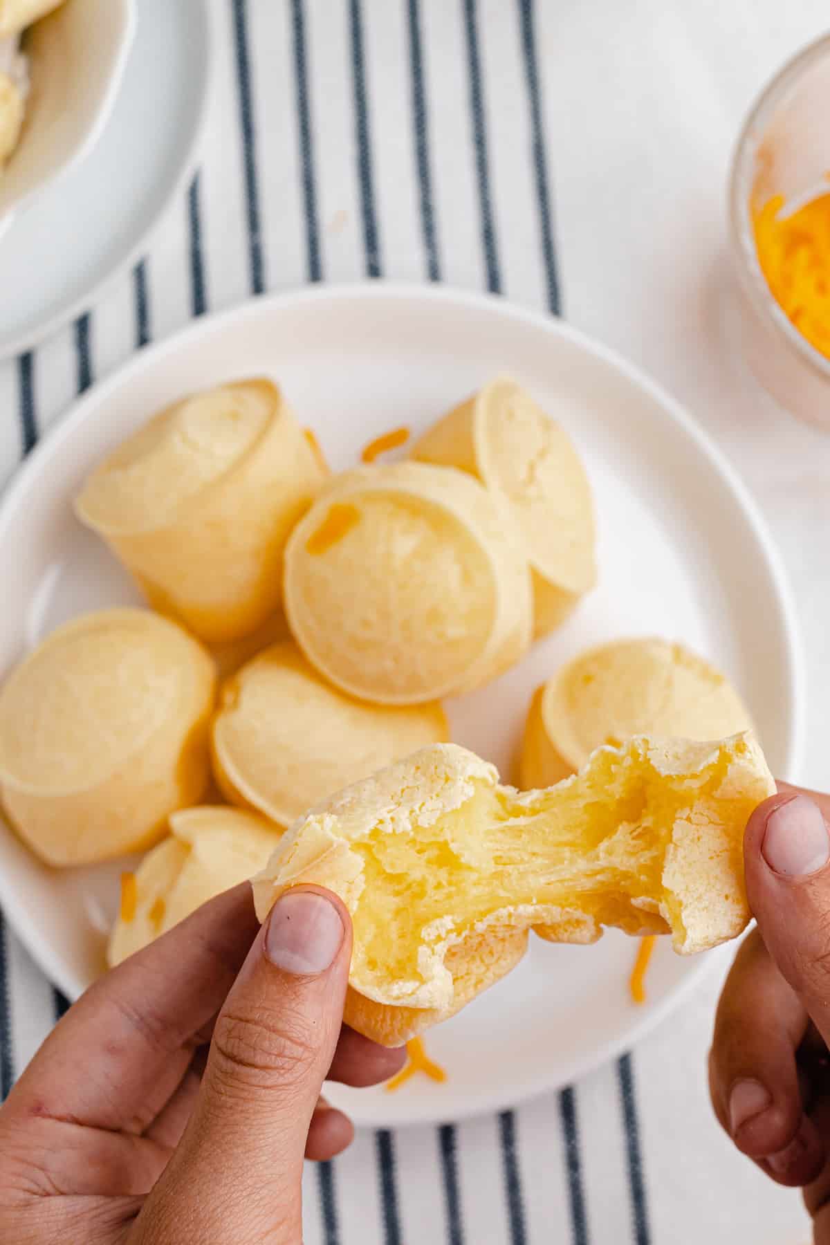 hands pulling apart a gluten free cheese bread muffin