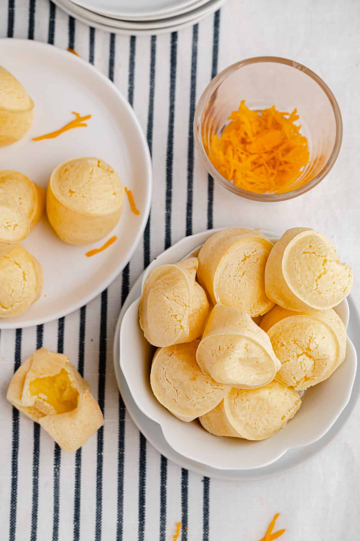 bowl of gluten free cheese bread muffins with a bowl of grated cheddar cheese