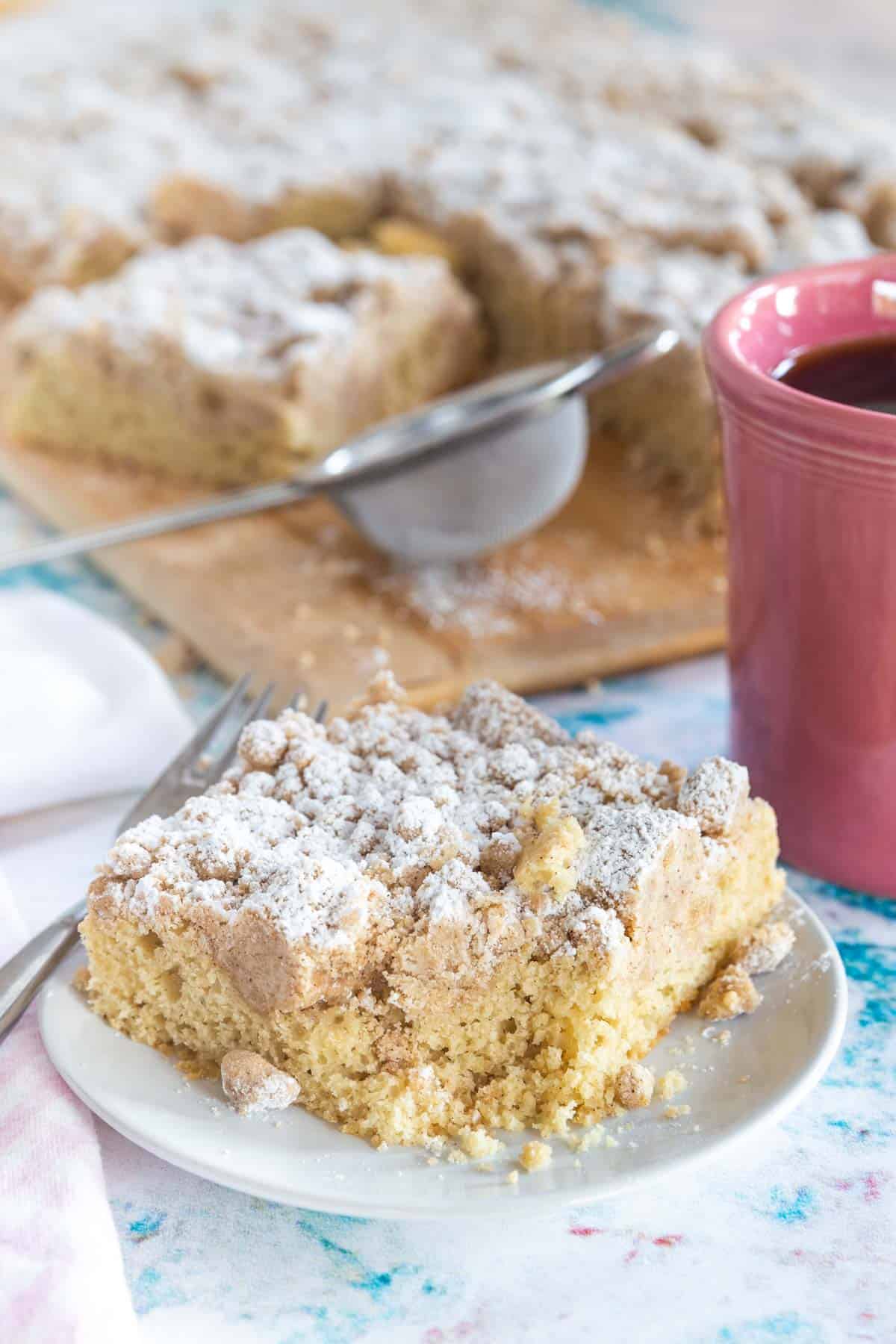 dusting a slice of crumb cake with powdered sugar