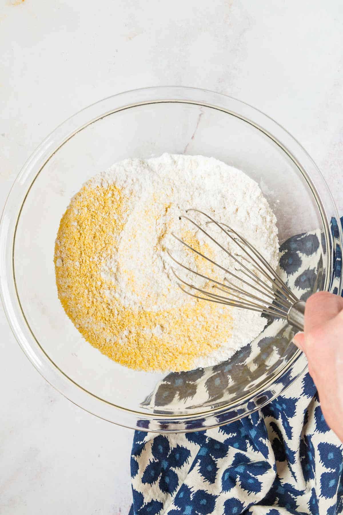 mixing bowl with cornmeal and flour being whisked