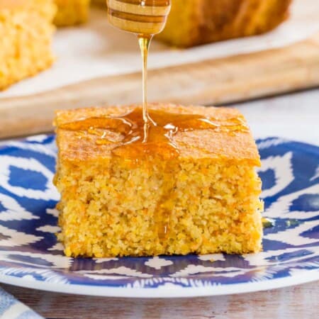 slice of cornbread with honey being drizzled on top