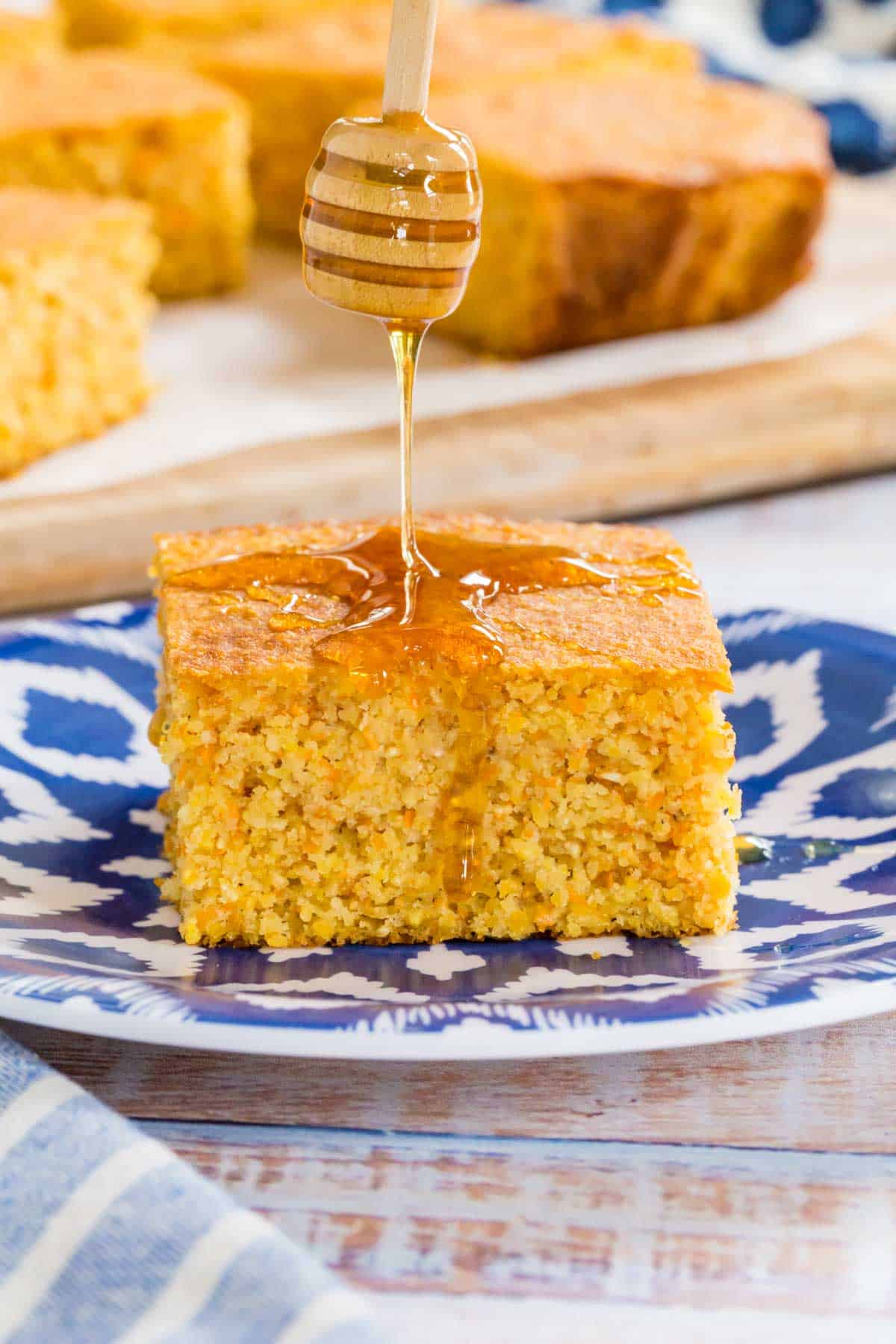 slice of cornbread with honey being drizzled on top