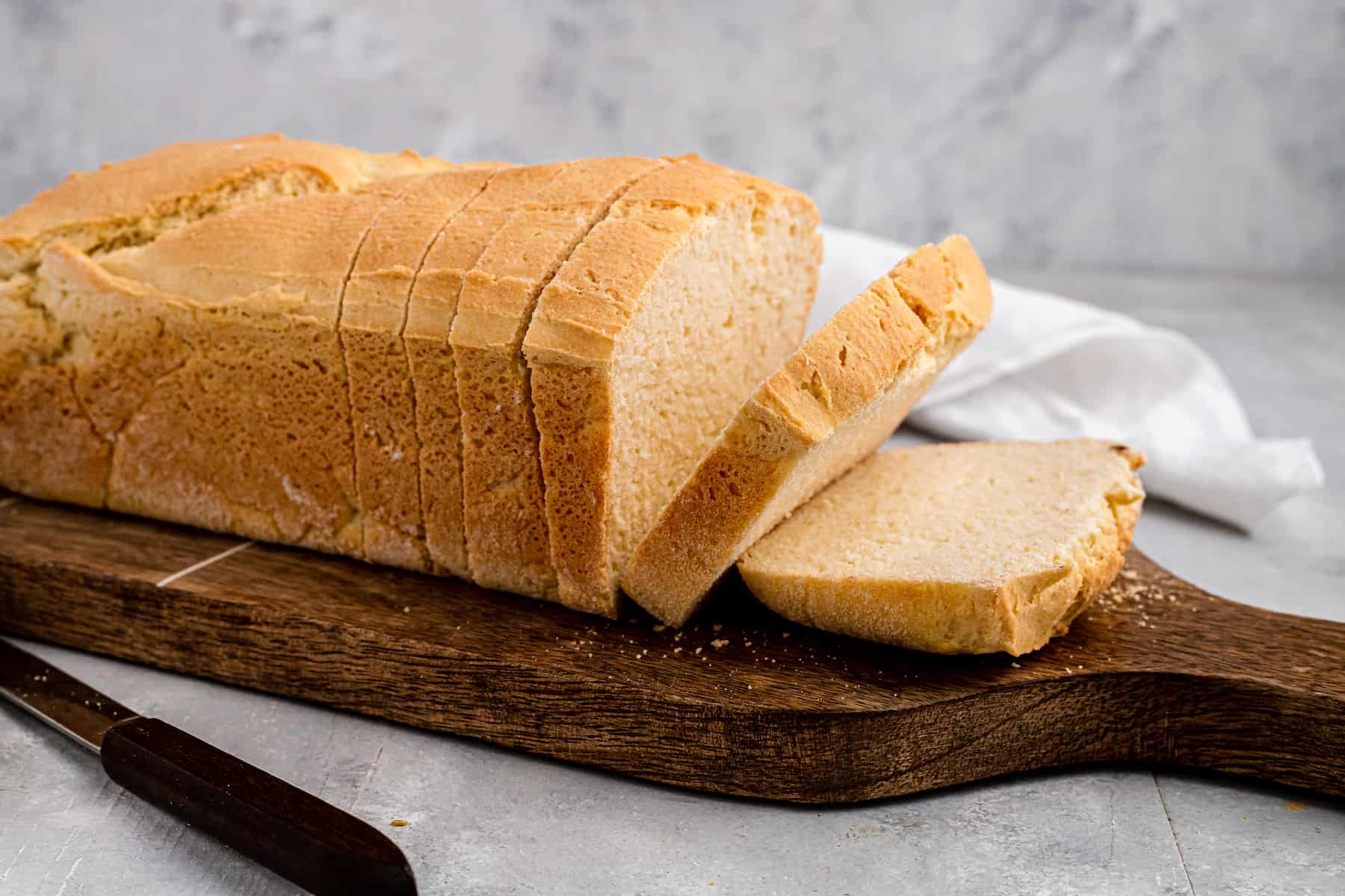 sliced loaf of sandwich bread on a wooden cutting board