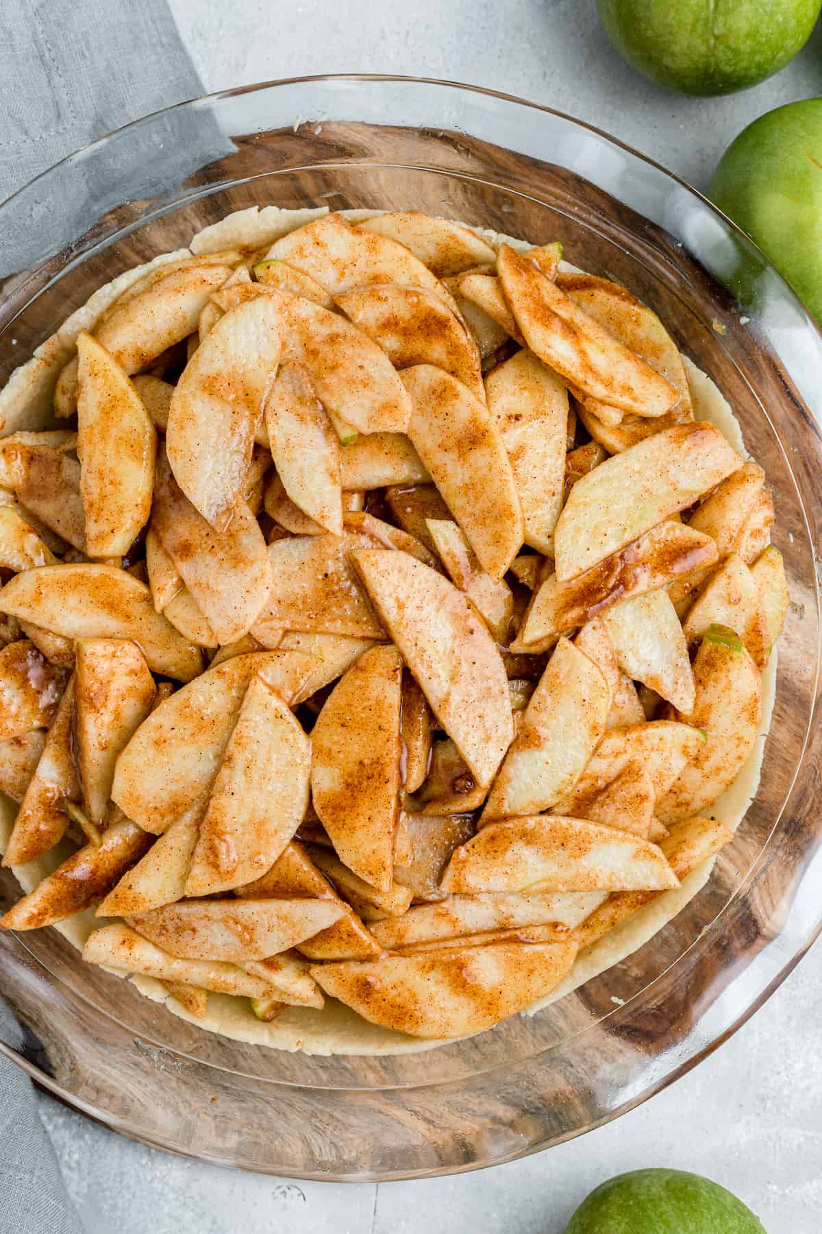 unbaked apple pie with no topping in a glass pie plate