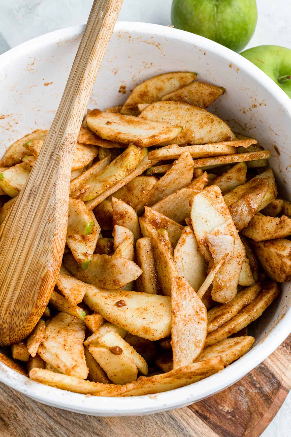 slices of apples in cinnamon sugar in a mixing bowl