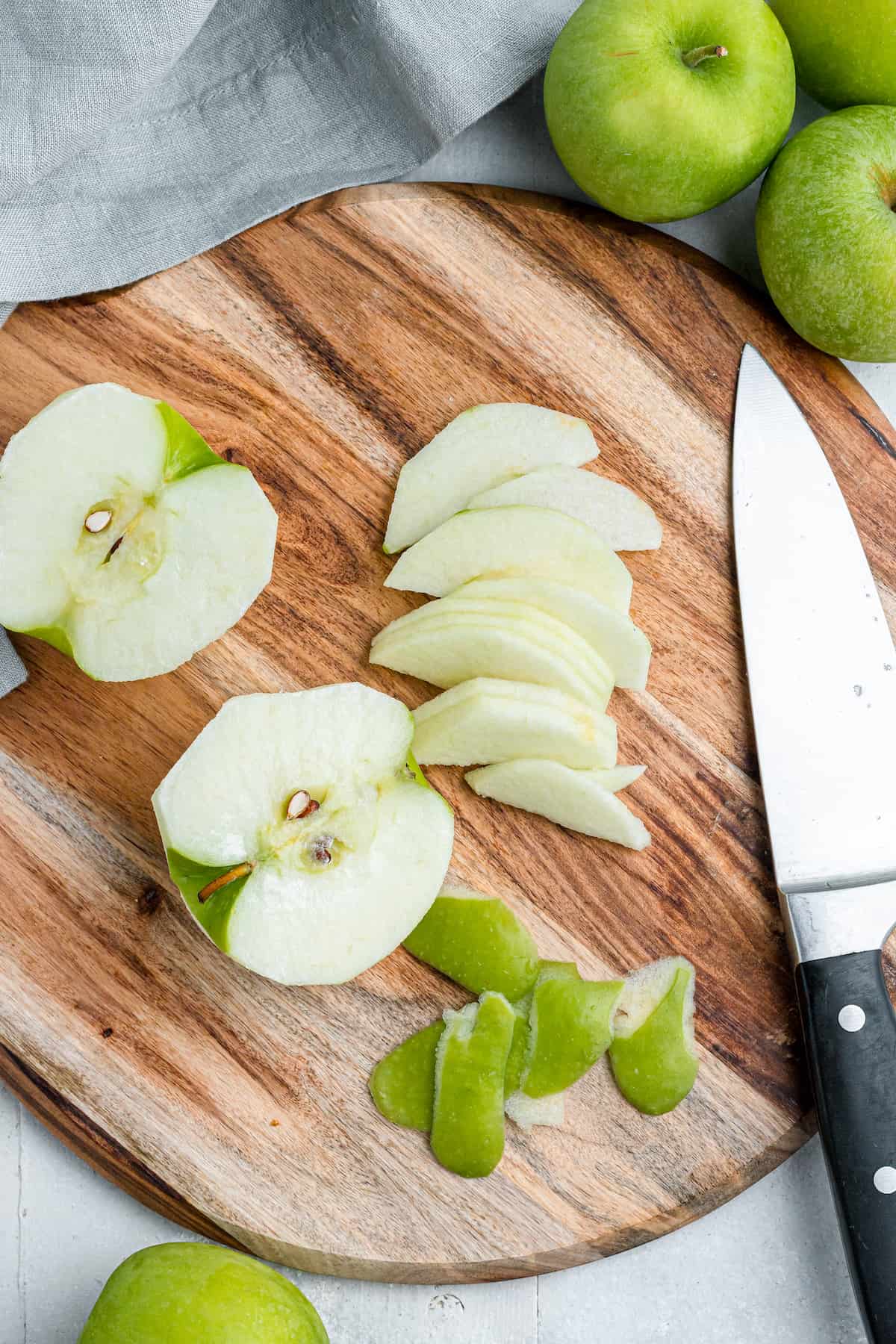 slicing green apples on a wooden cutting board