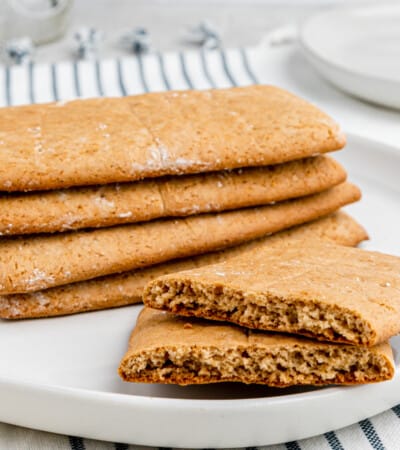Graham crackers on a plate with one broken in half.