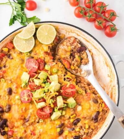 serving spoon resting in a pan of ground beef taco skillet with a scoop already missing from the pan