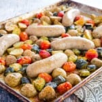 baking sheet with roasted turkey sausage, chunks of potatoes and zucchini, and grape tomatoes