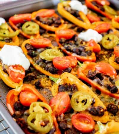 black bean bell pepper nachos with melted cheese on a sheet pan sitting on a cooling rack