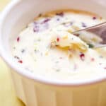 butter knife scraping up a curl of cranberry orange butter in a small white ramekin