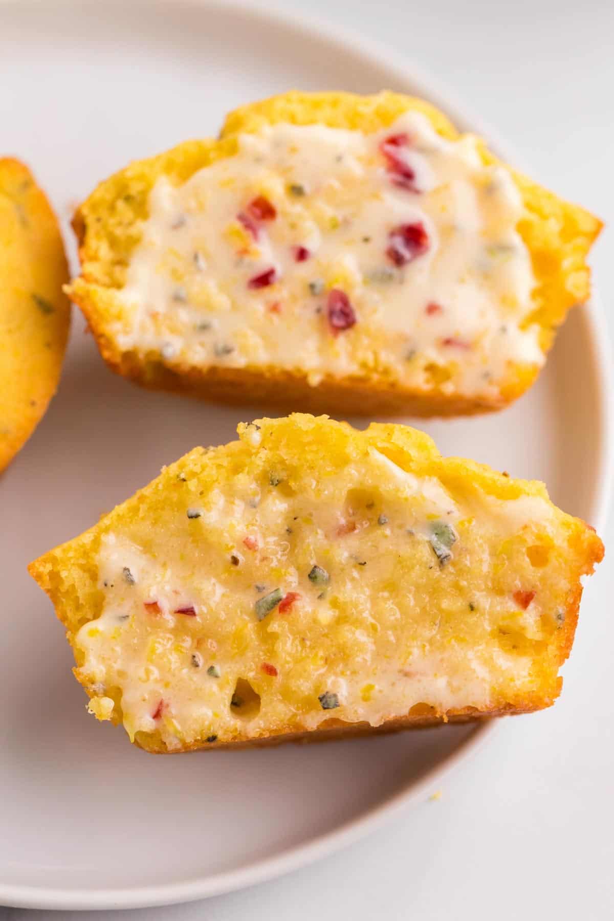 corn muffin cut in half with cranberry orange butter melting on it
