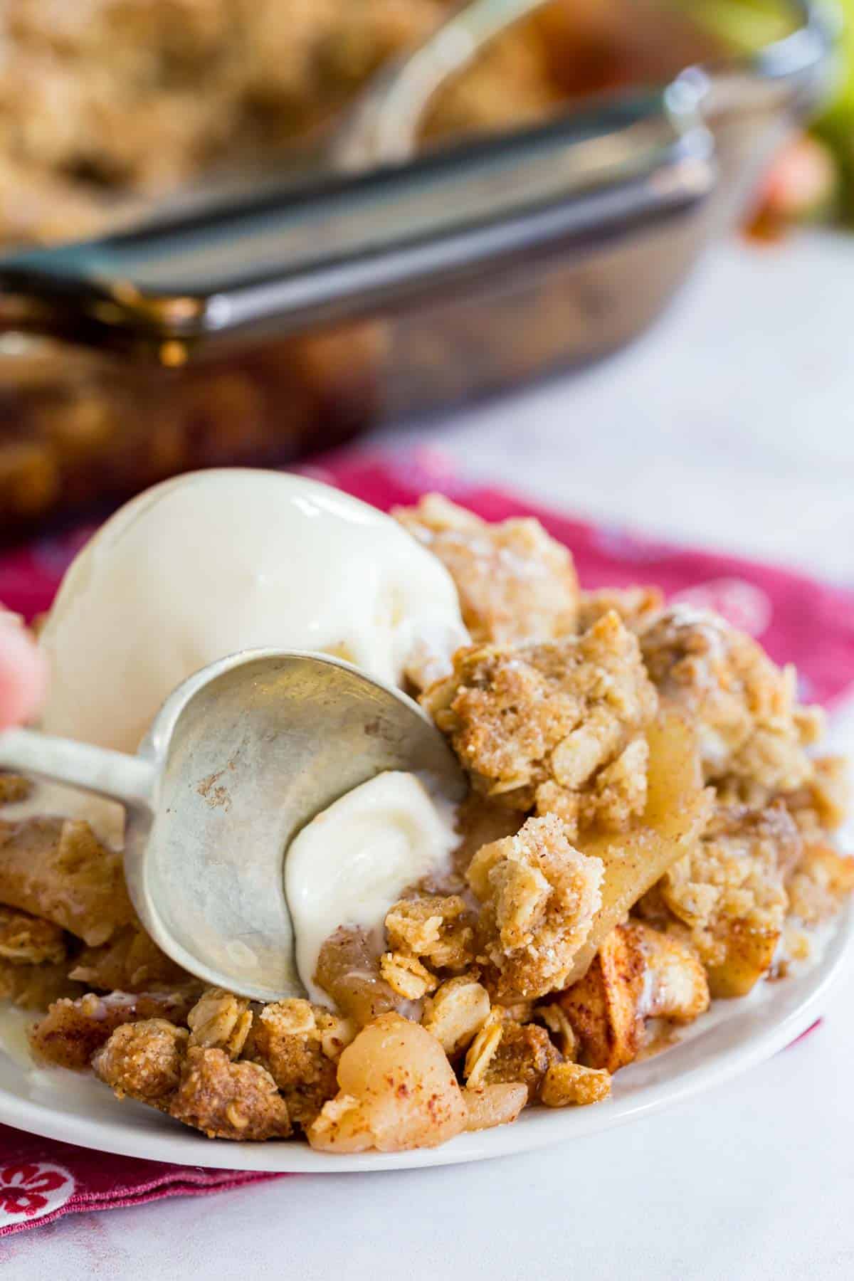 using a spoon to get a bite of apple crisp and ice cream