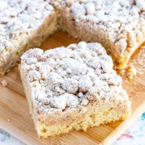 piece of crumb cake on a small plate with a bite taken missing