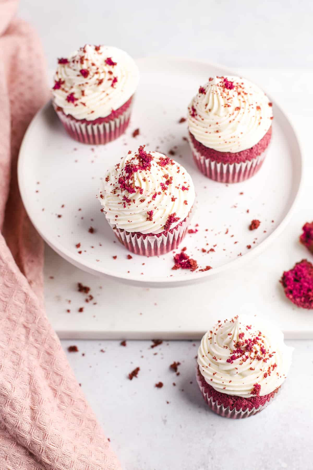 cake tray with frosted red velvet cupcakes topped with cake crumbs