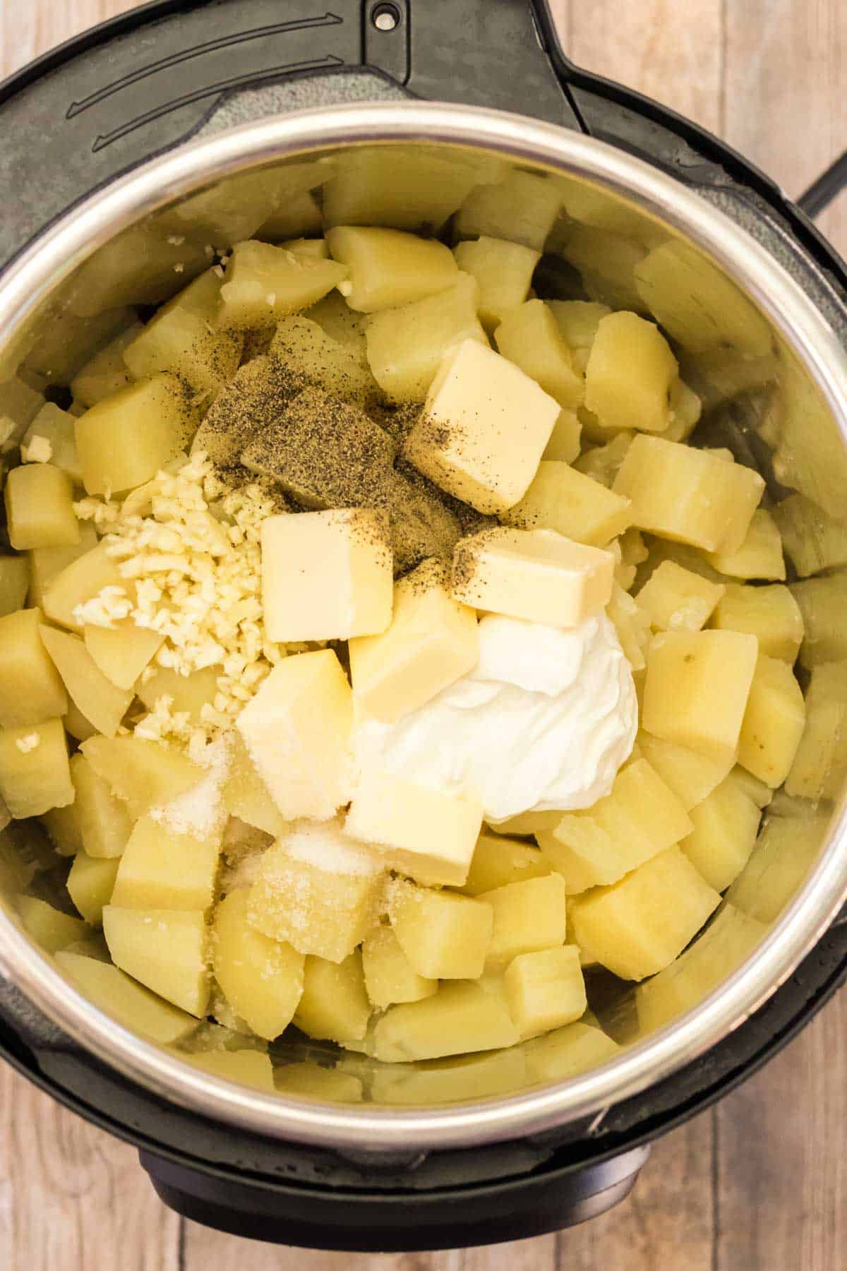 instant pot with cooked potatoes, butter, sour cream and garlic