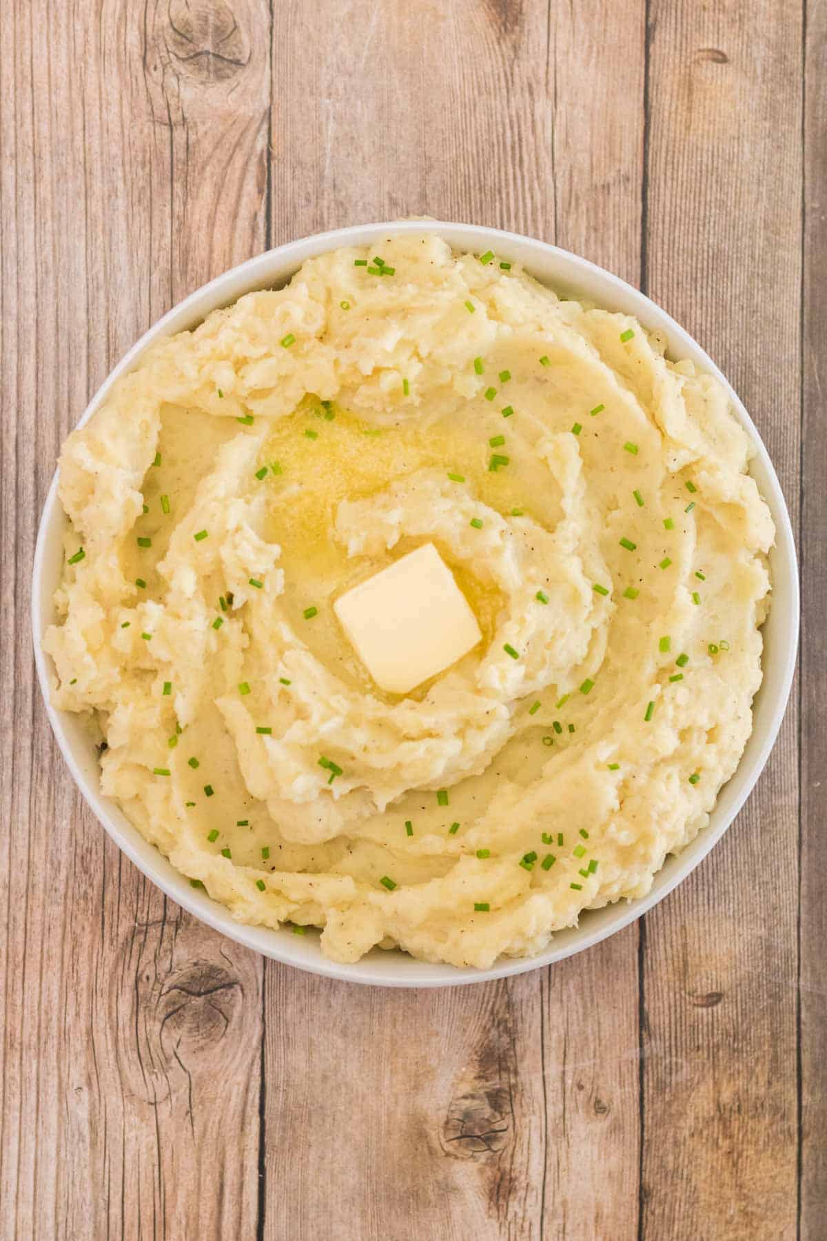 white bowl with mashed potatoes topped with butter