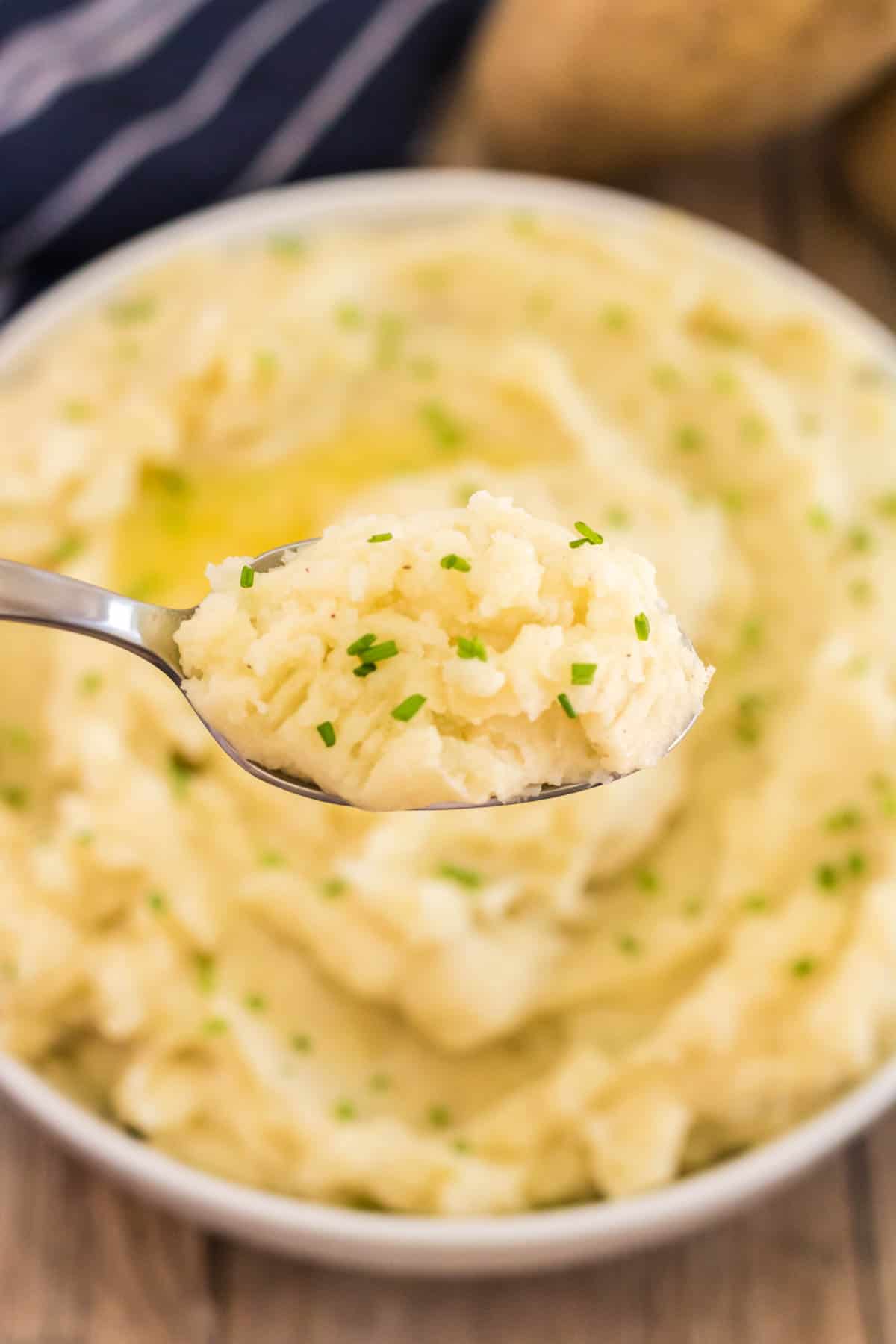 spoon of instant pot mashed potatoes with buttr and chives