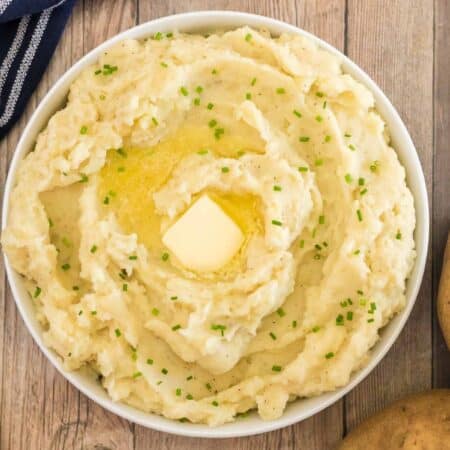 bowl of mashed potatoes with a pat of butter in the center