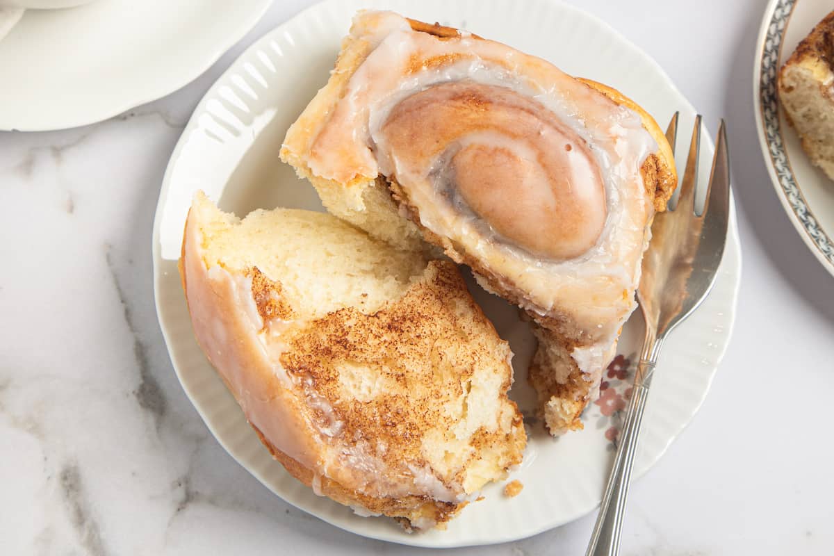 gluten free cinnamon roll on a plate with one side torn off