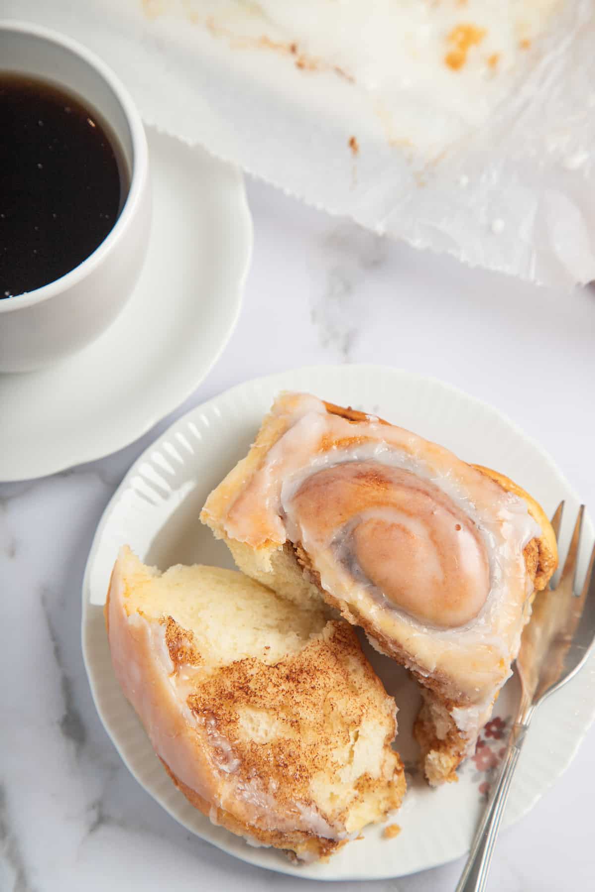 gluten free cinnamon roll on a plate with one side torn off