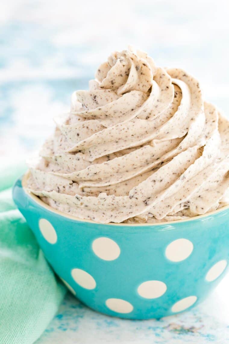 a perfect swirl of cookies and cream frosting in a blue and white polka dot bowl