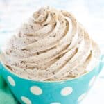 gluten free oreo frosting in a pale blue bowl with white polka dots next to a mint green cloth napkin