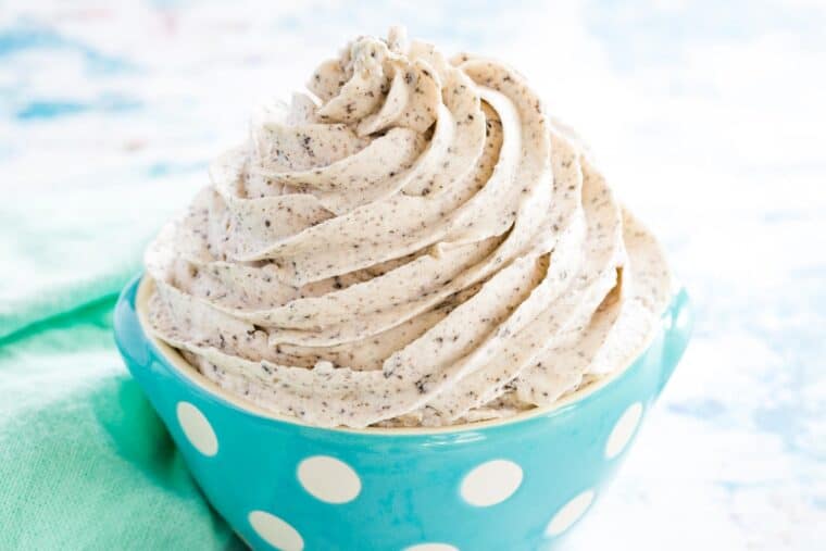 gluten free oreo frosting in a pale blue bowl with white polka dots next to a mint green cloth napkin