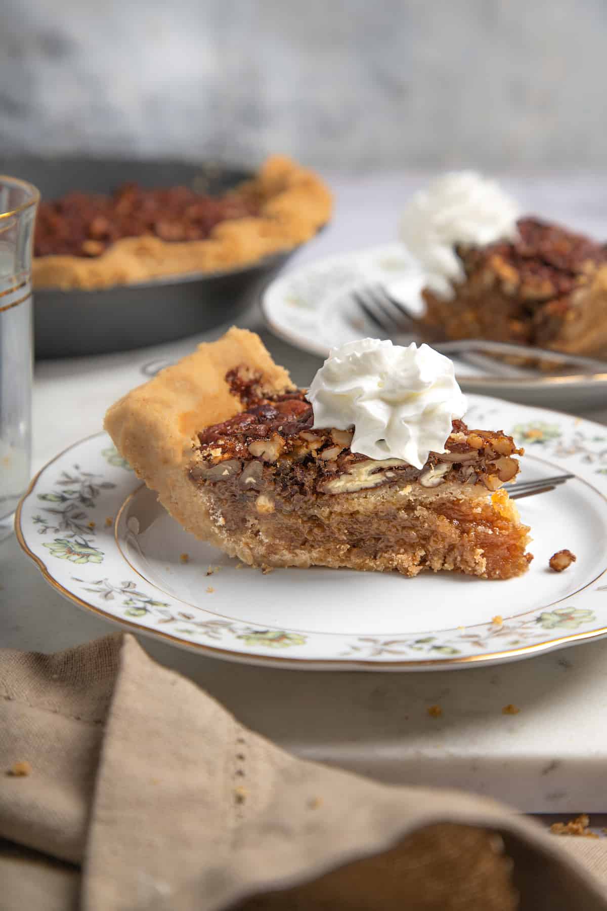 thick slice of pecan pie with whipped cream