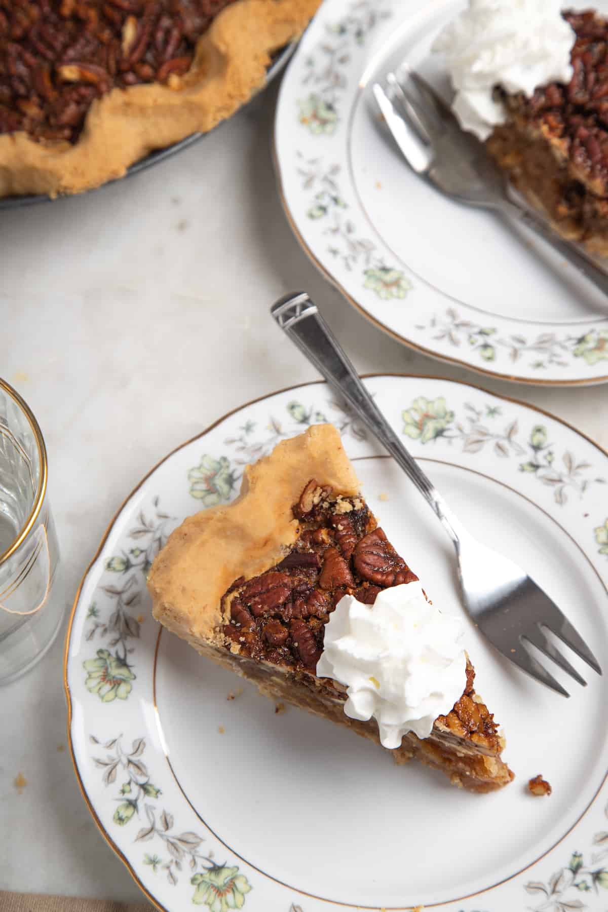 slcie of pecan pie with whipped cream on a white plate