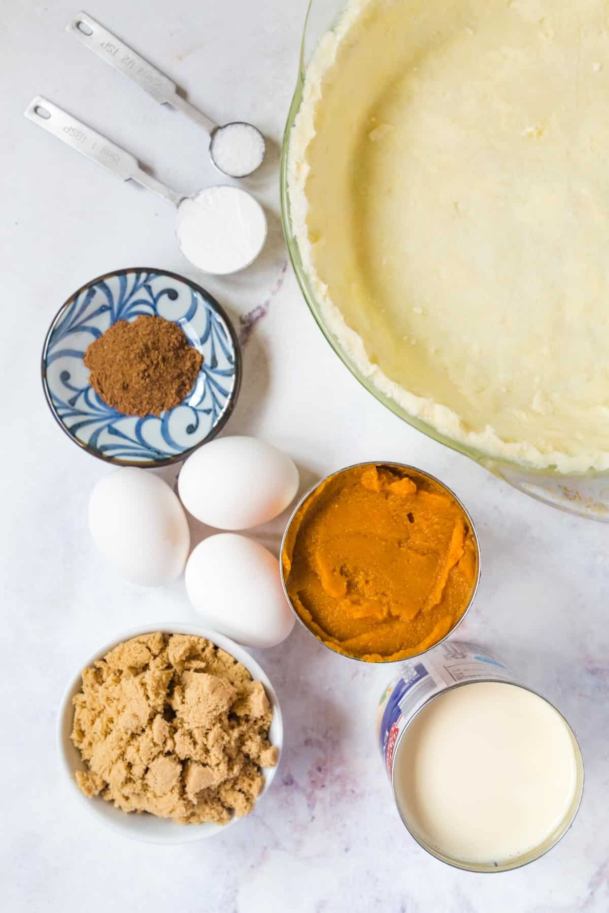 ingredients for pumpkin pie with spices, sugar and eggs