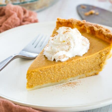 slice of pumpkin pie with whipped cream on top