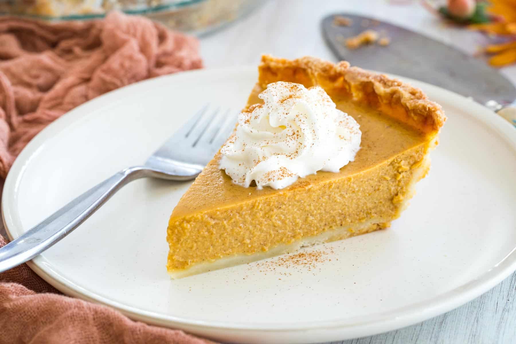 slice of pumpkin pie with whipped cream on top