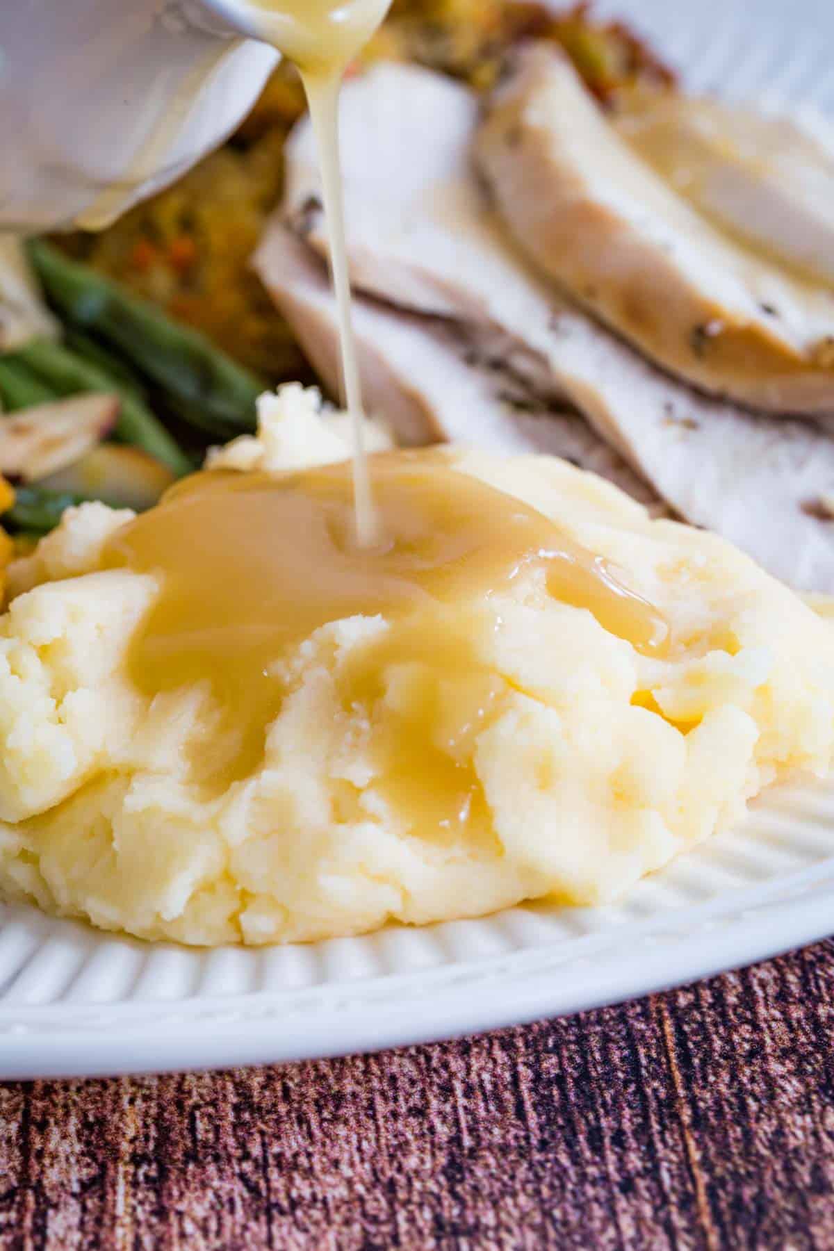 pouring gluten free gravy on mashed potatoes