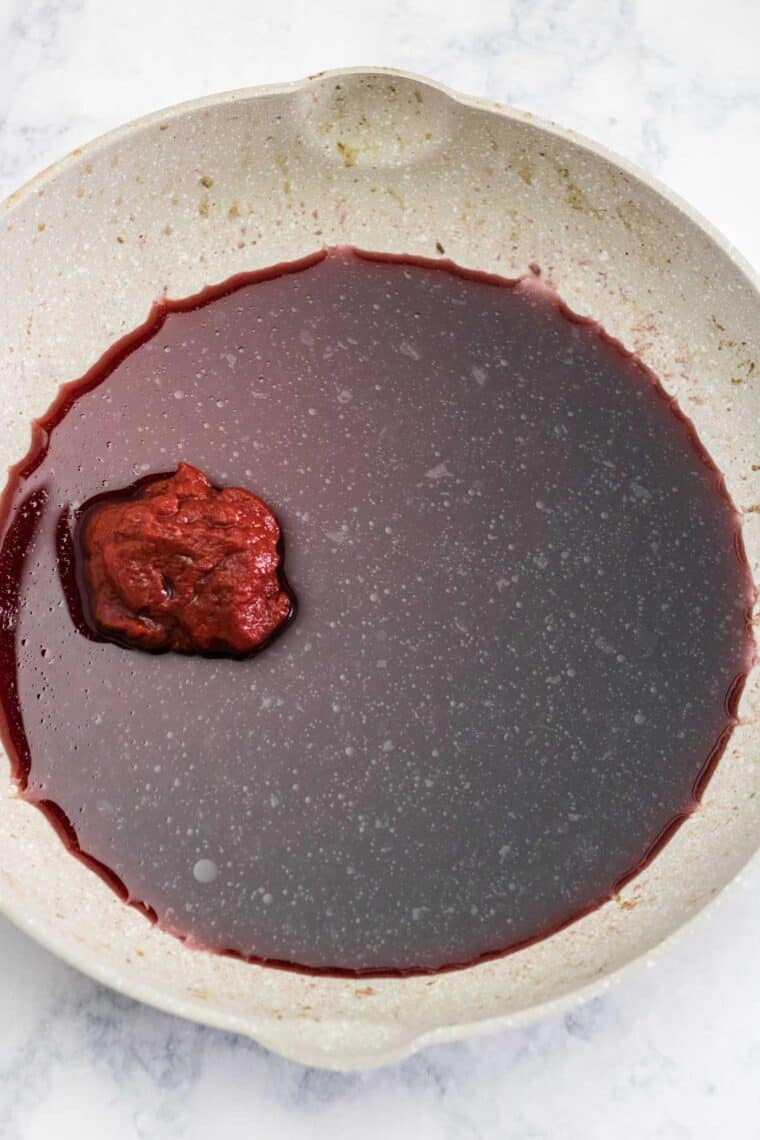 wine and tomato paste in a skillet