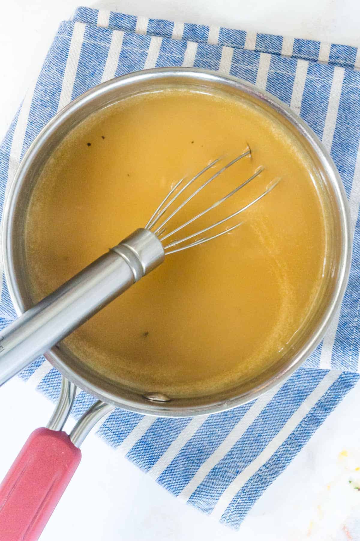 saucepan with creamy turkey gravy and a whisk