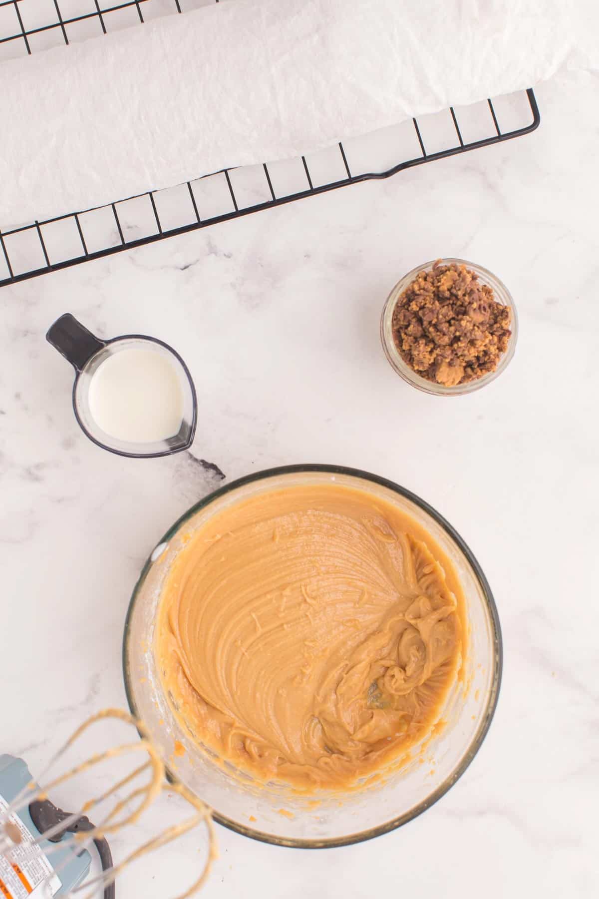 bowl of peanut butter mousse with a small beaker of heavy cream and a bowl of chopped peanut butter cups