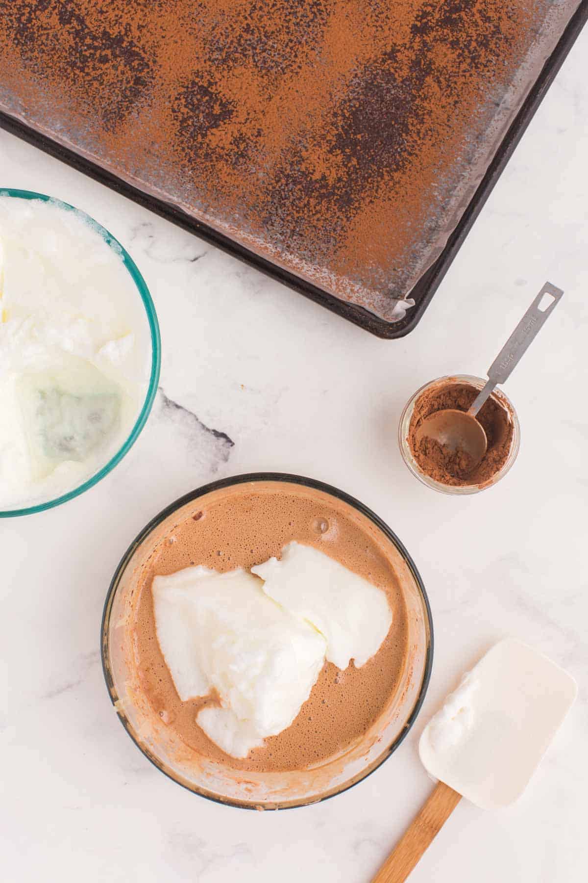 portion of whipped egg whites added to the bowl of the chocolate cake batter