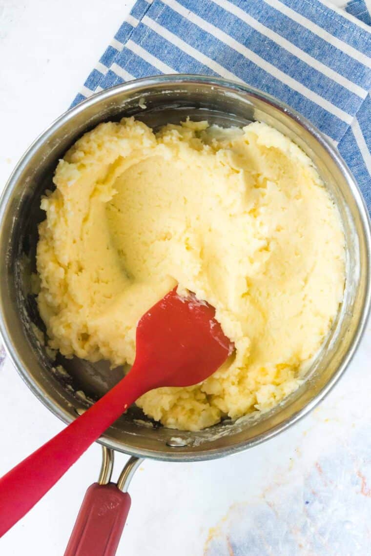 red spatula in a pot of mashed potatoes