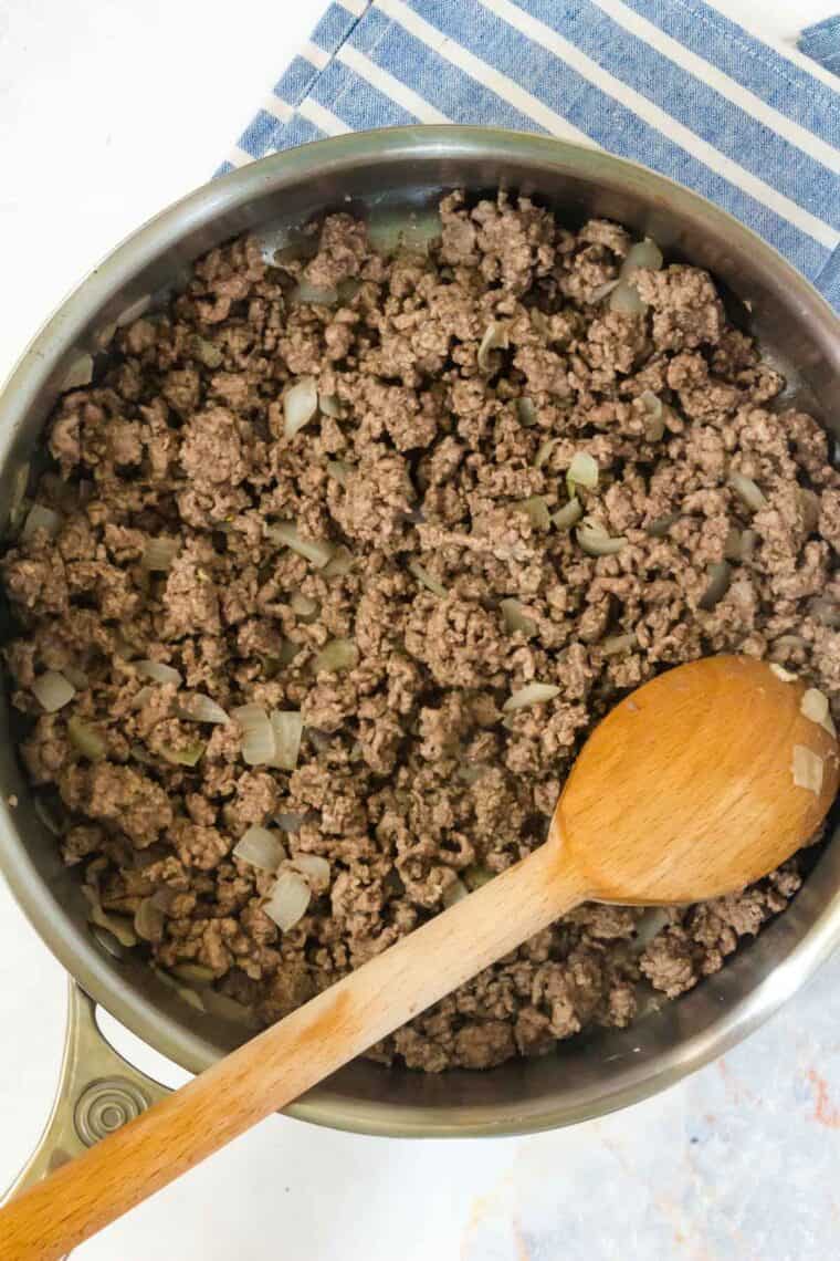 skillet with browned ground beef and cooked onions