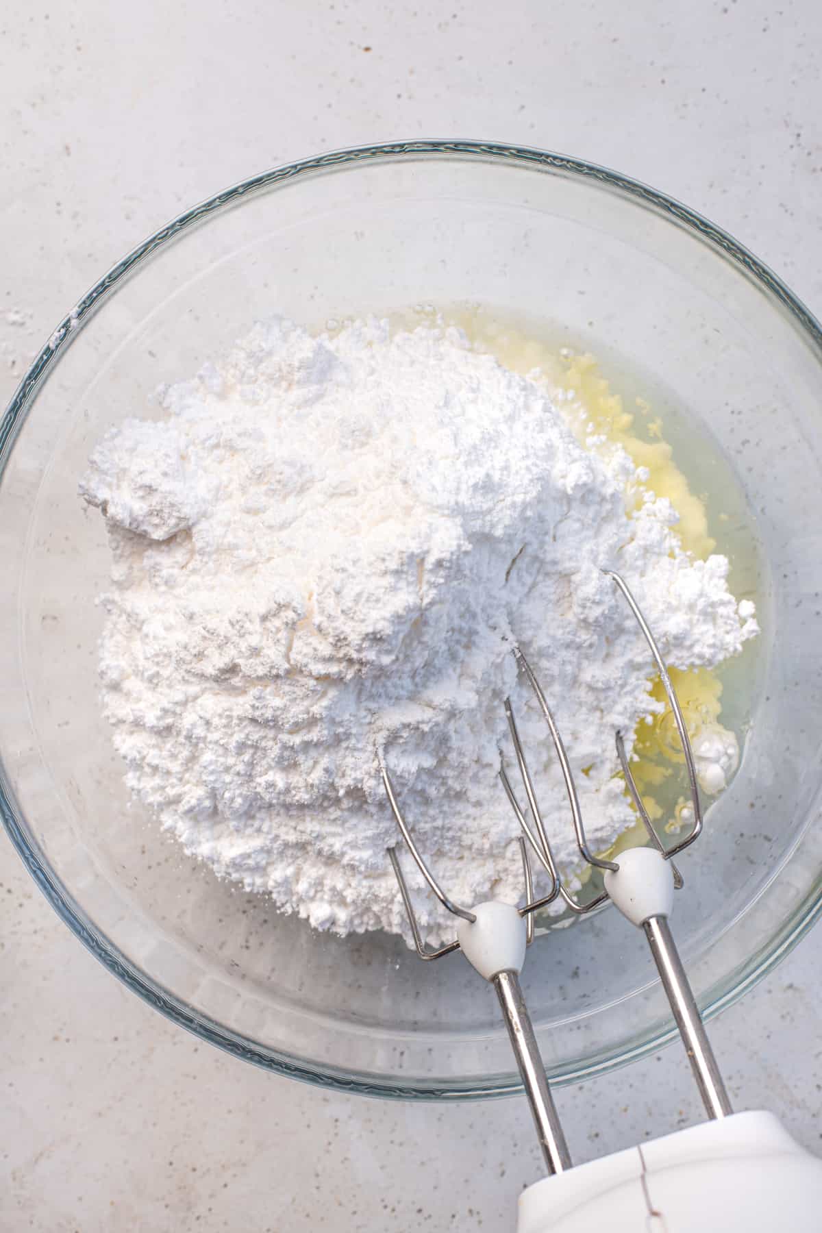 mixing bowl with egg whites and powdered sugar