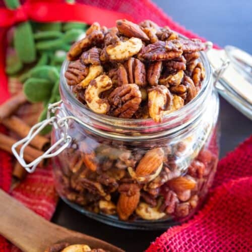 Candied spiced mixed nuts in a glass jar.
