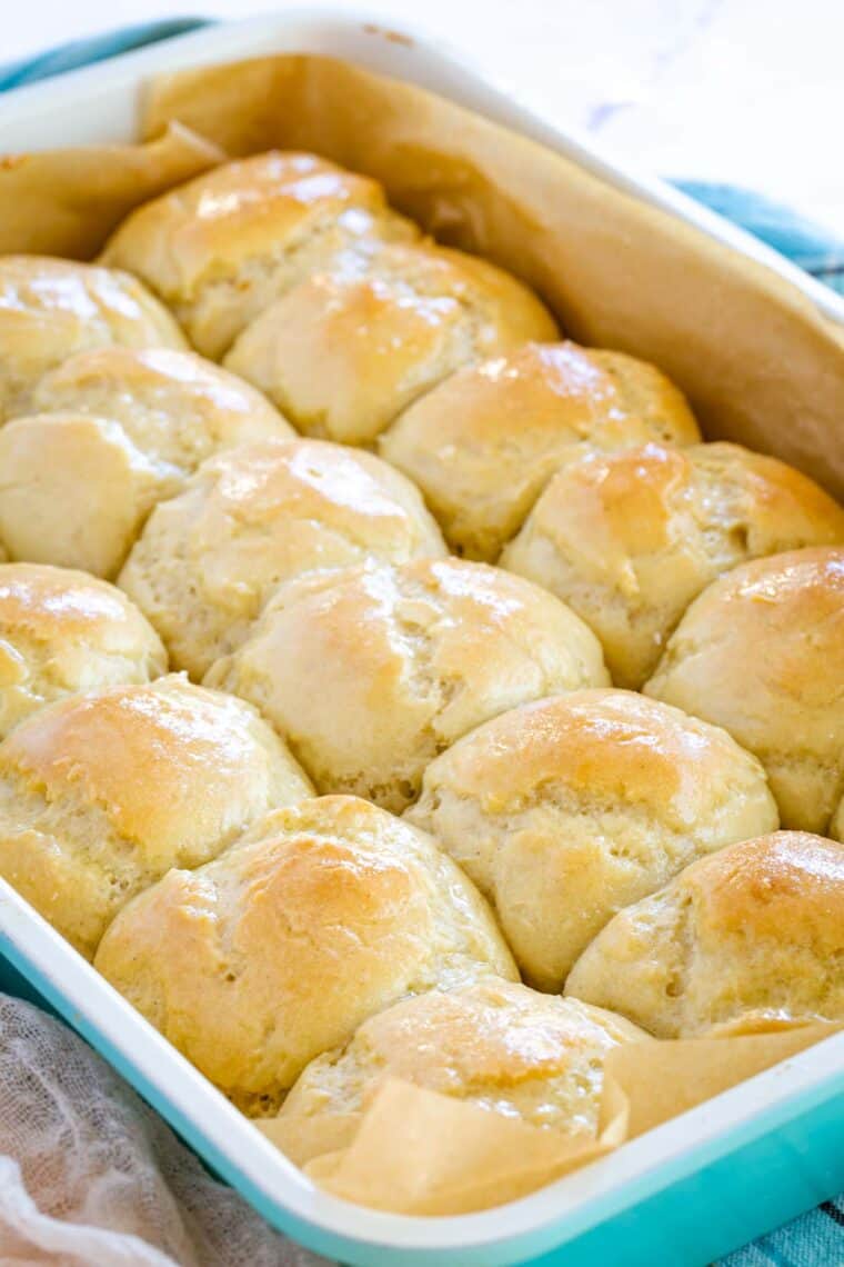 a baking pan of gluten free dinner rolls with buttery tops