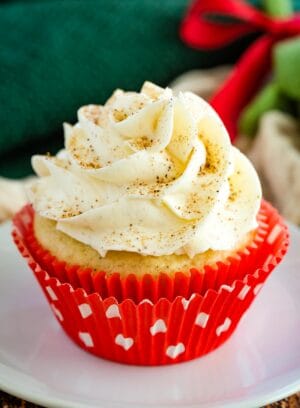 A gluten free eggnog cupcake in a red wrapper with white polka dots.