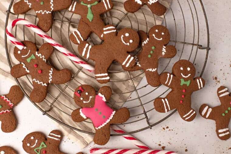 gingerbread men scattered on a cooling rack and countertop