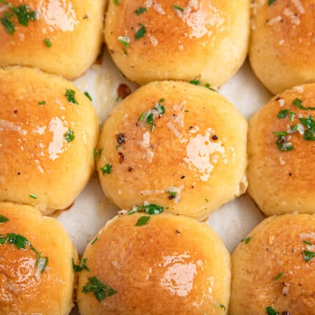 rows of garlic butter dinner rolls with parsley