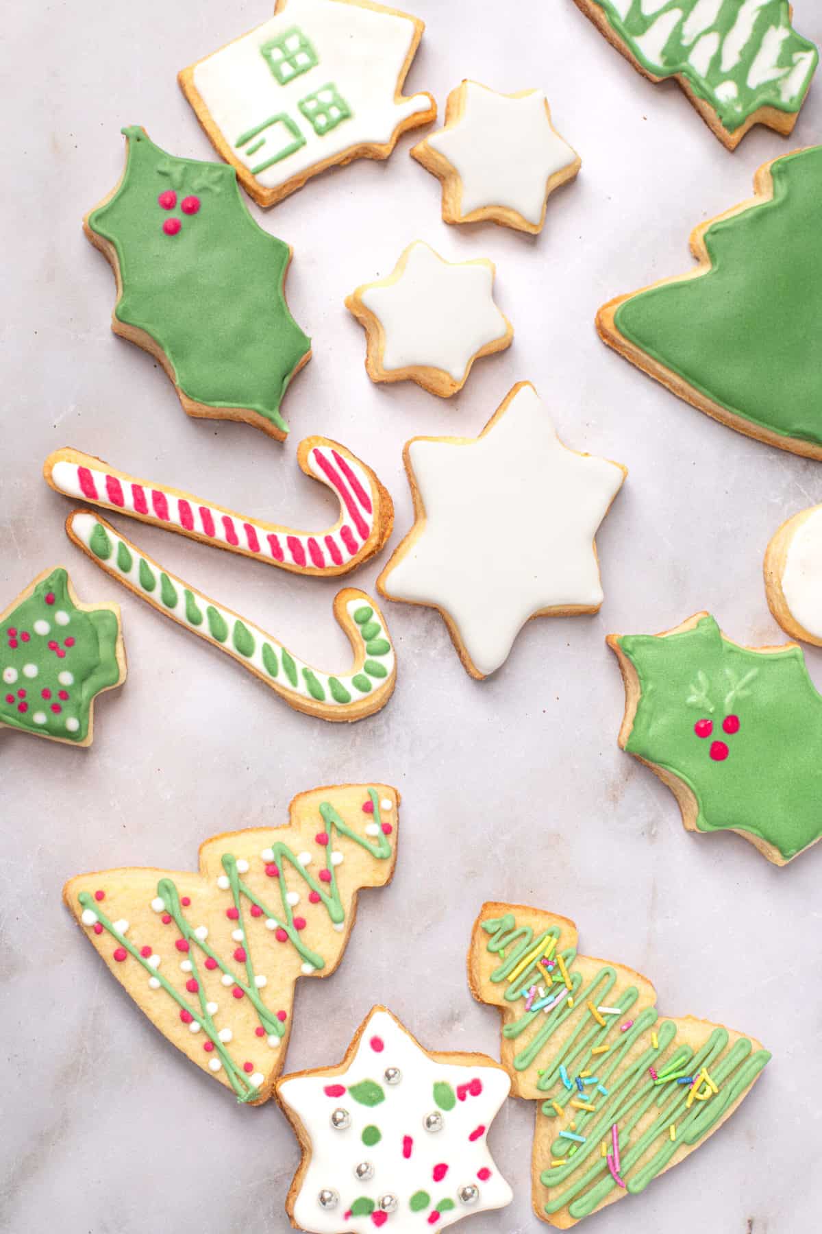 gluten free sugar cookies decorated for Christmas and scattered on a table 