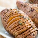 hasselback sweet potatoes on a white serving plate